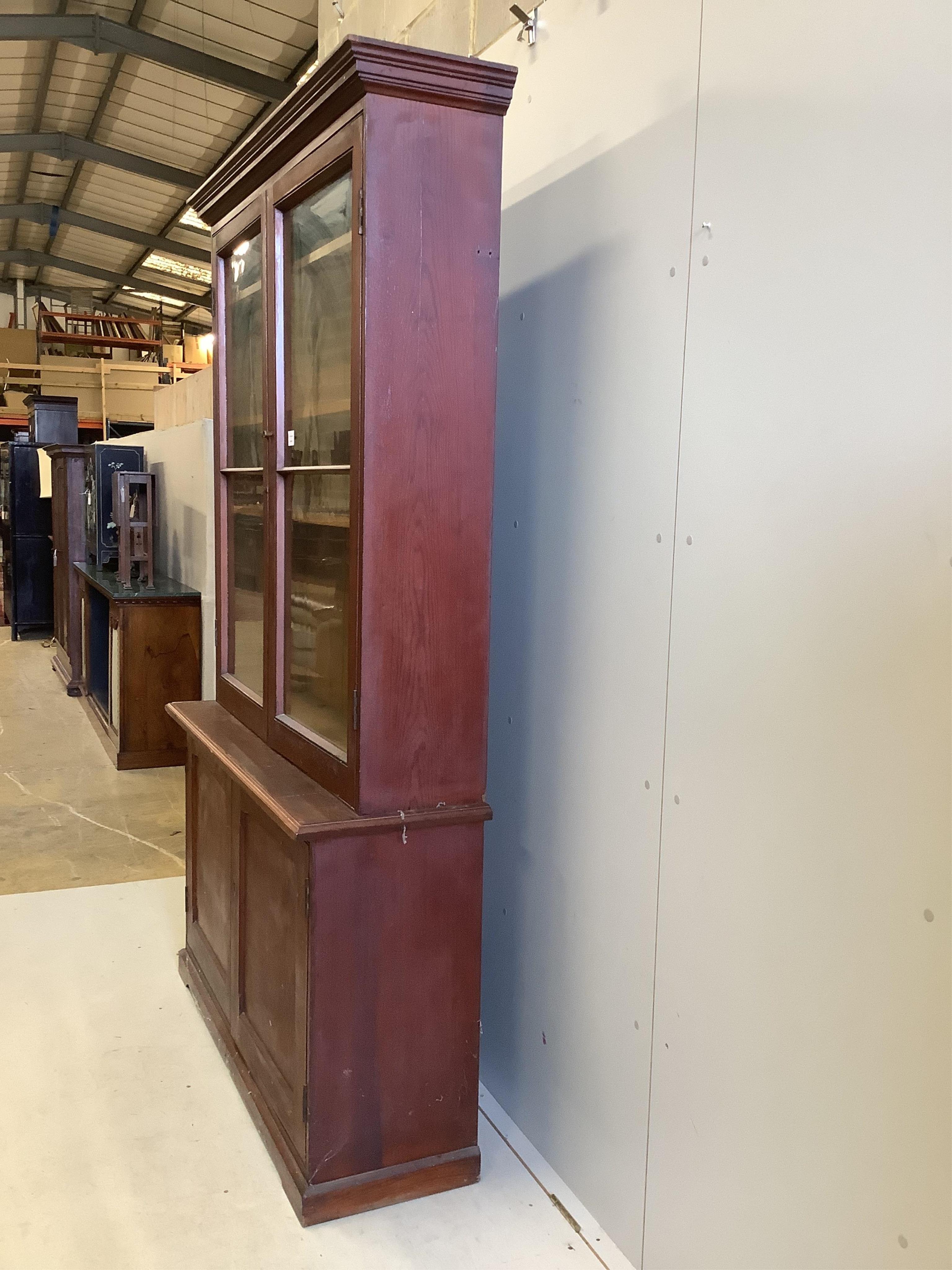 A late Victorian pine bookcase cupboard, width 130cm, depth 40cm, height 214cm. Condition - poor to fair